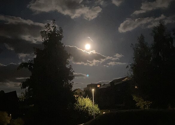 Der Vollmond zeigt sich von prächtigen Wolken umgeben